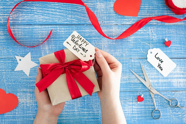 Arrière-plan du jour de la Saint-Valentin avec boîte à cadeaux sur fond bleu en bois vue supérieure