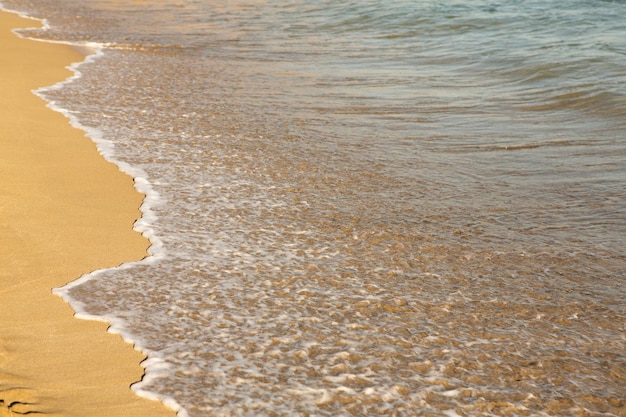 Arrière-plan avec du sable doré sur la côte de l'île de Crète.