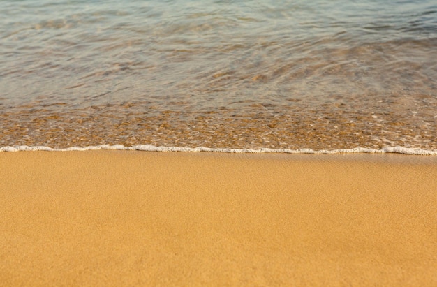 Arrière-plan avec du sable doré sur la côte de l'île de Crète.