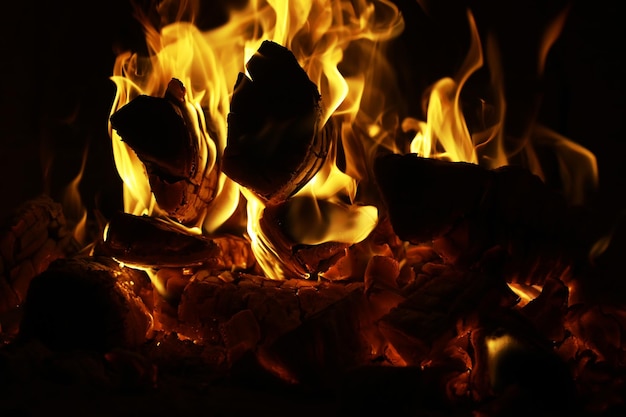 Arrière-plan de la flamme dans le four Langues de feu dans une cheminée en briques Texture feu