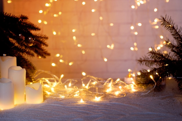 Arrière-plan flou avec une guirlande lumineuse avec des branches de sapin pour un collage sur le thème du nouvel an et de noël.