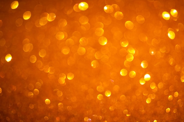 Arrière-plan flou orange. Lumières de paillettes vintage, photo de fond d'effets de noël brillant