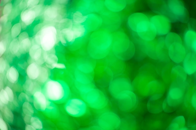 Arrière-plan flou vert de bokeh scintillant de guirlandes. Fêter le Nouvel An et Noël.