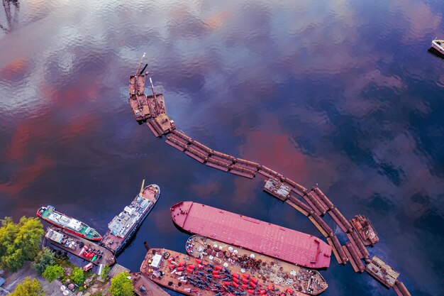 Arrière-plan industriel d'art abstrait avec espace de copie. Jetée abandonnée et bateaux avec reflet du ciel dans l'eau. Vue aérienne rapprochée du drone.