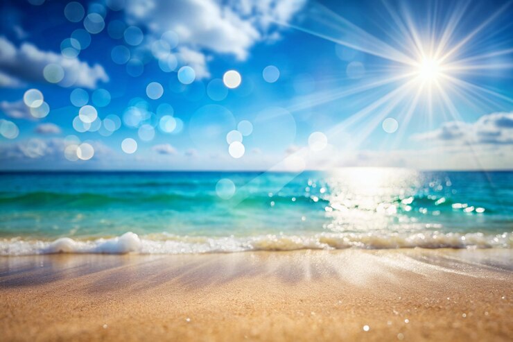 Photo arrière-plan naturel flou défoulé pour les vacances d'été conceptuelles nature de plage d'été tropicale avec des rayons de soleil plage de sable léger l'eau de l'océan scintille contre le ciel bleu