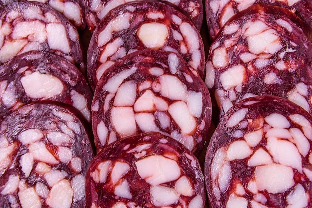 Arrière-plan des nombreux morceaux de saucisse de salami en tranches