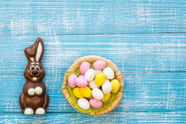 Arrière-plan de Pâques avec un lapin au chocolat et des œufs au chocolat colorés