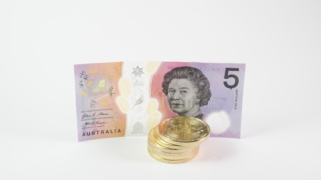 Arrière-plan avec pièces de crypto-monnaie Bitcoin et dollar australien Concept de crypto-monnaie Bitcoin Bitcoin BTC argent virtuel et billets de banque en dollars australiens