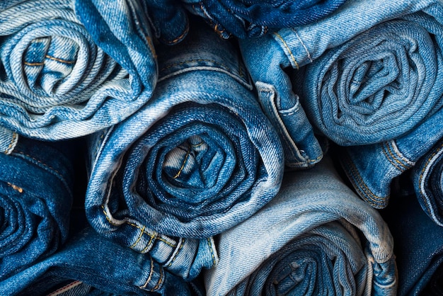 arrière-plan d'une pile de jeans roulés