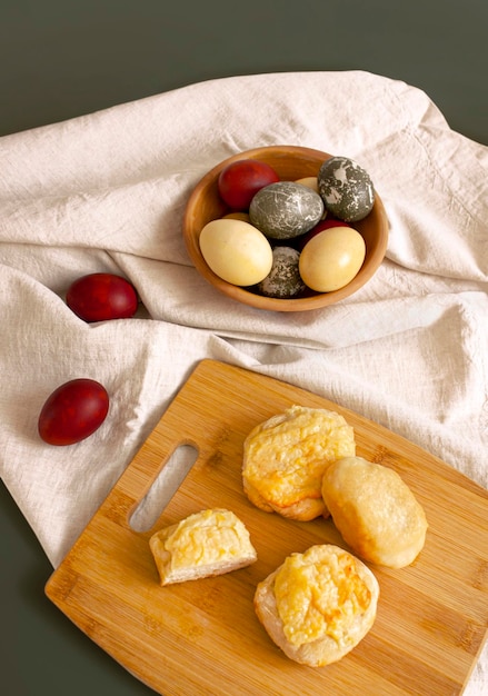 Arrière-plan rustique Oeufs de Pâques rustiques colorés et produits de boulangerie faits maison sur un tissu tissé