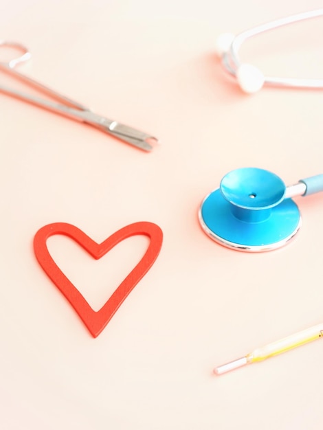 Arrière-plan de la santé avec un stéthoscope cardiaque, des ciseaux et un thermomètre