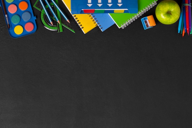 Arrière-plan scolaire au tableau noir avec des fournitures scolaires