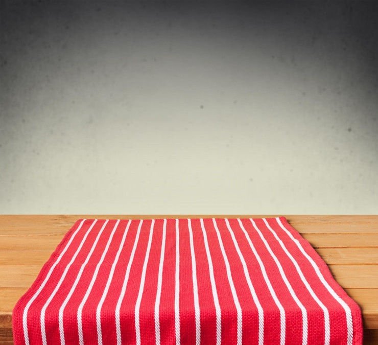 Photo arrière-plan avec une table en bois vide avec une nappe rayée et un mur grunge
