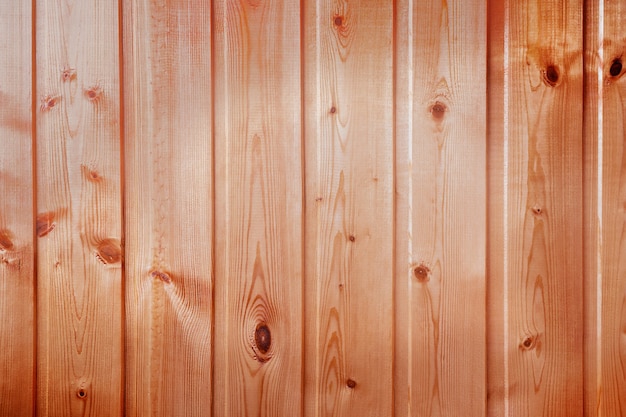 Arrière-plan ou toile de fond fait de planches de bois de couleur brune et chaude posées verticalement