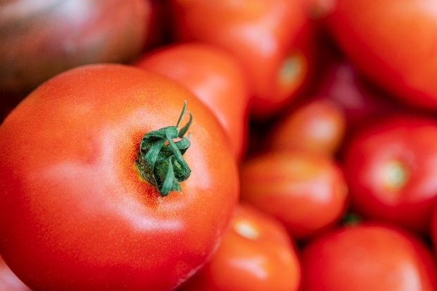 Photo arrière-plan de tomates rouges fraîches naturelles sans traitement supplémentaire. le concept de produits naturels sans ogm.