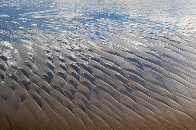 Arrière-plan des vagues dans le sable générées par les vagues de la mer et le soleil