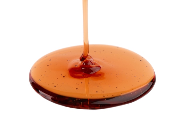 Arrosage de sirop de caramel isolé sur fond blanc Éclaboussures de sauce au caramel sucré