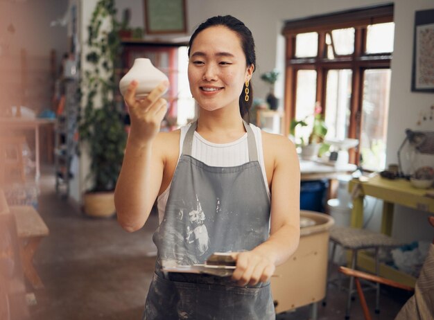 Art créatif et femme en atelier avec de la céramique en pot d'argile et de la poterie avec créativité et fierté au travail Heureux artiste avec sculpture de texture et création à la main avec presse-papiers pour la vérification du produit