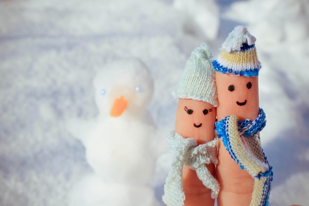 Art de doigt d'un couple heureux sur le fond de la neige.