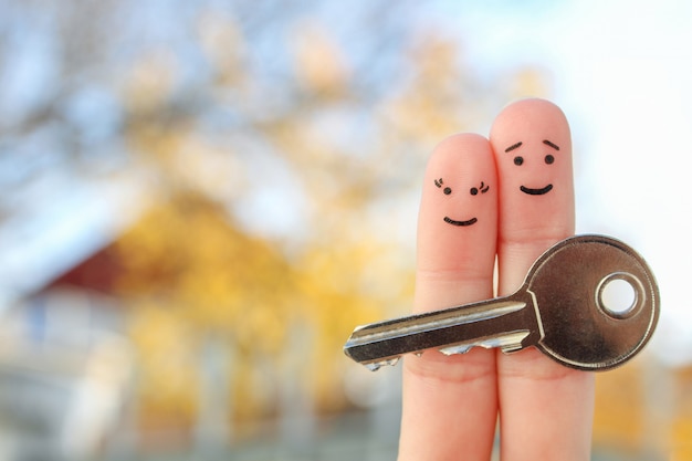 Art des doigts de couple heureux. La famille détient la clé de la maison.