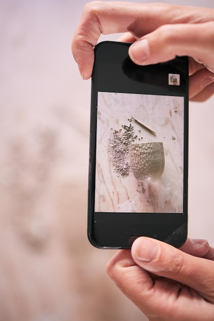 Photo l'art du téléphone et les mains prennent une photo créative ou une photo d'un artisanat en argile lors d'un atelier pour la mise à jour des médias sociaux artiste fier et personne artistique prenant une création photo avec un appareil photo mobile