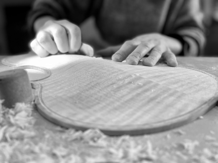 Photo l'art de faire du violon luthor au travail façonnant le dessus et le dos en bois d'épinette et d'érable