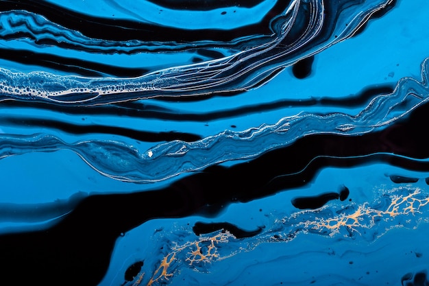 Art fluide. Vague dorée dans un océan abstrait de peinture bleue. Arrière-plan ou texture effet marbre.