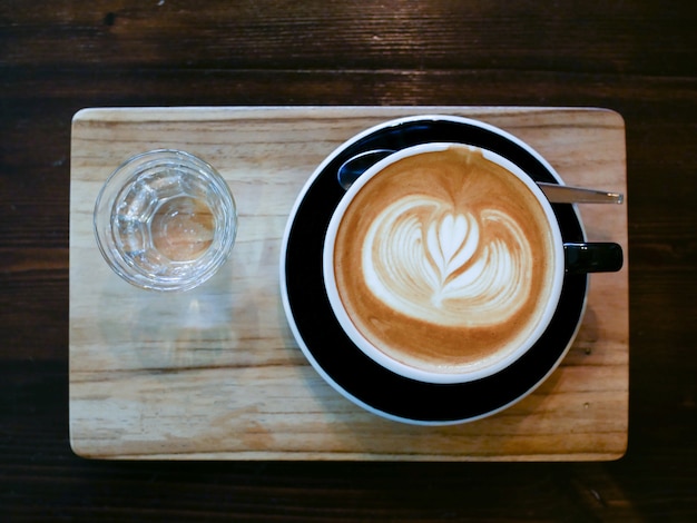 Photo art latte agrandi de café tasse marron sur la surface de la table en bois