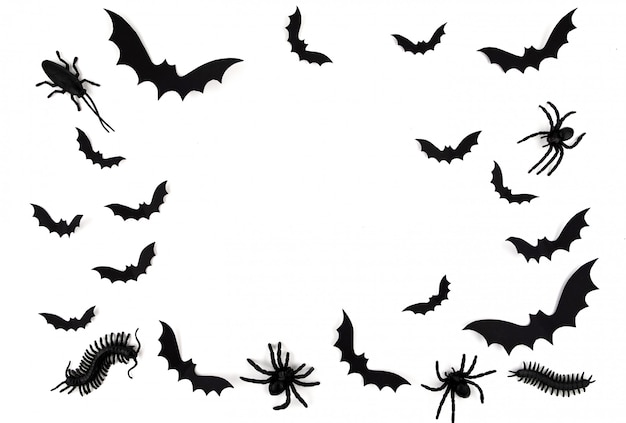 Art de papier d'Halloween. Voler des chauves-souris en papier noir, des coléoptères et des araignées sur blanc.