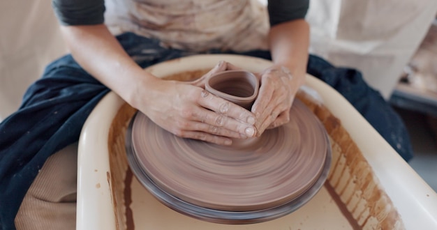 Art de la poterie et mains sur un tour de potier avec un artiste qui tourne de l'argile dans un atelier ou un studio de classe créative Artisanat de créativité et gros plan d'un sculpteur travaillant sur l'artisanat ou la création de conception en céramique