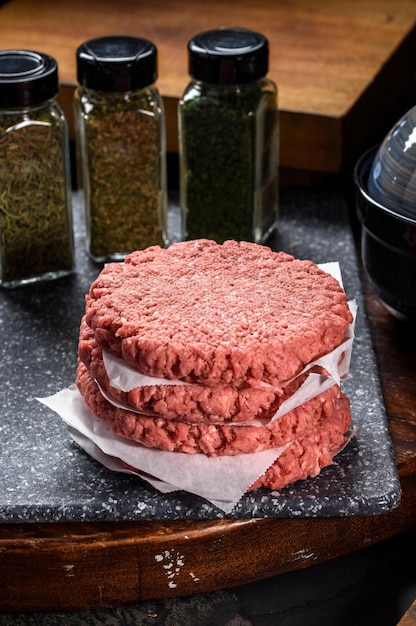 L'art de la préparation Gros plan de Raw Hamburger Patty sur une planche de bois prêt à être assaisonné Showca