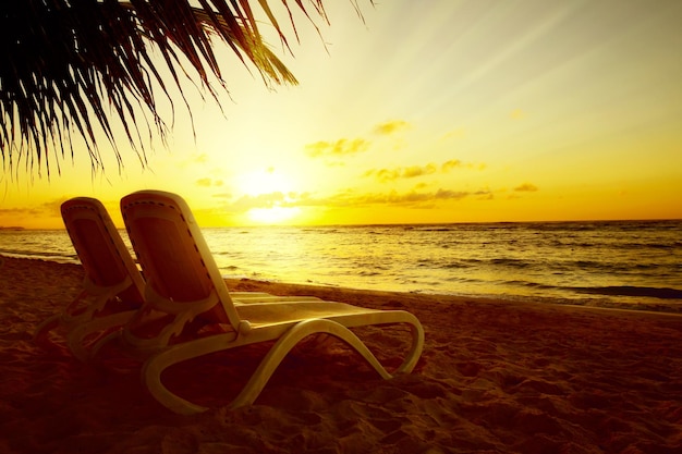 Art Vue du lever du soleil à la station paysage de vacances relaxant Deux chaises longues sur la plage avec un palmier