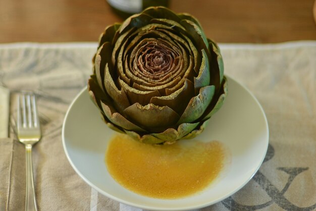 Artichaut français sur une assiette avec une sauce vinaigrette