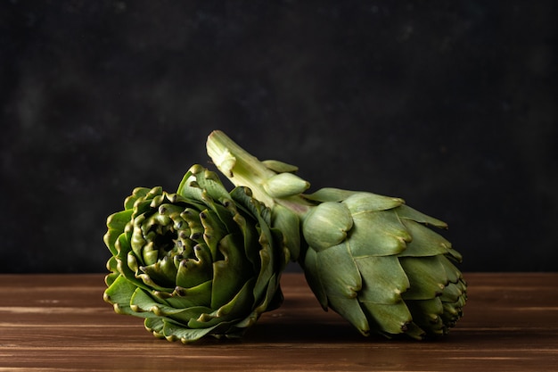 Artichauts biologiques mûrs sur une table en bois rustique.