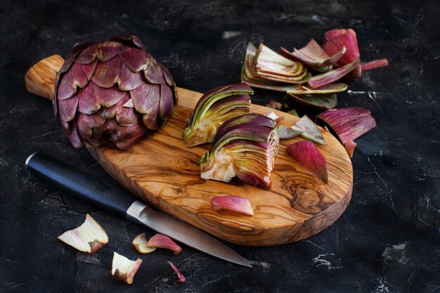 Artichauts romains sur une planche de bois avec couteau