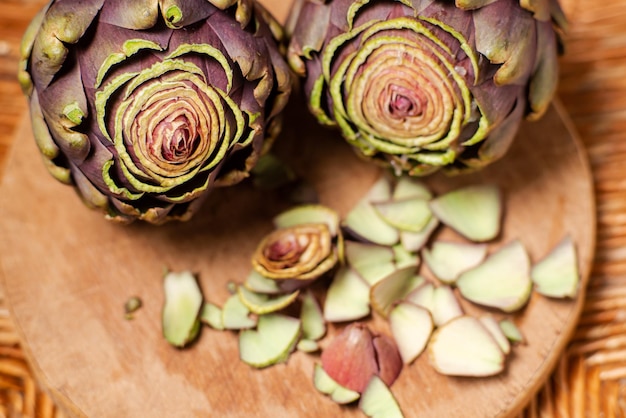 Artichauts violets sur fond de bois Artichauts avec le haut coupé Préparation pour la cuisson d'aliments sains végétaliens