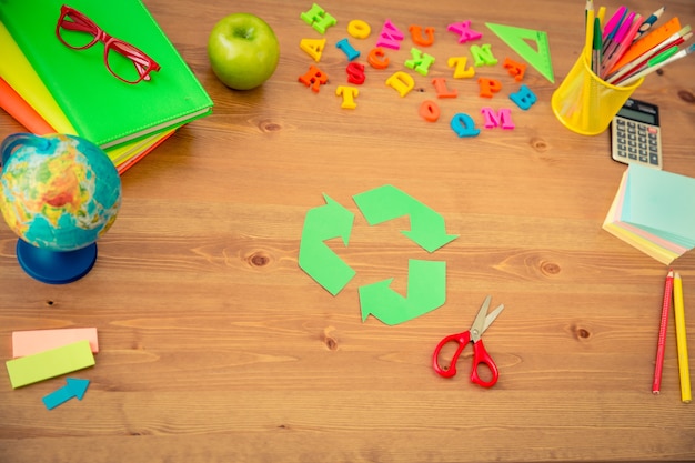 Articles scolaires sur un bureau en bois en classe. Notion d'éducation. Vue de dessus