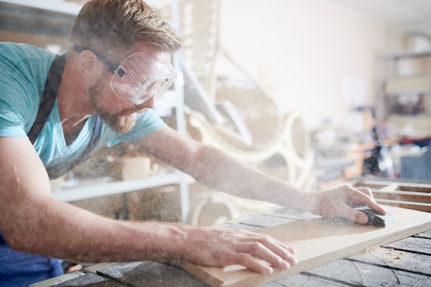 Artisan à l'aide de papier de verre