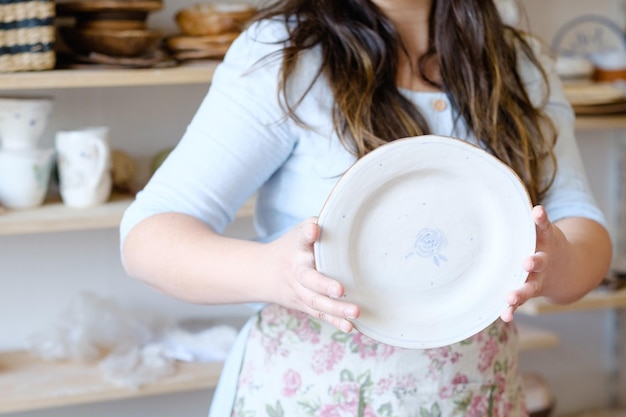 Artisan d'atelier de poterie montrant un concept de vaisselle faite à la main de plaque d'argile