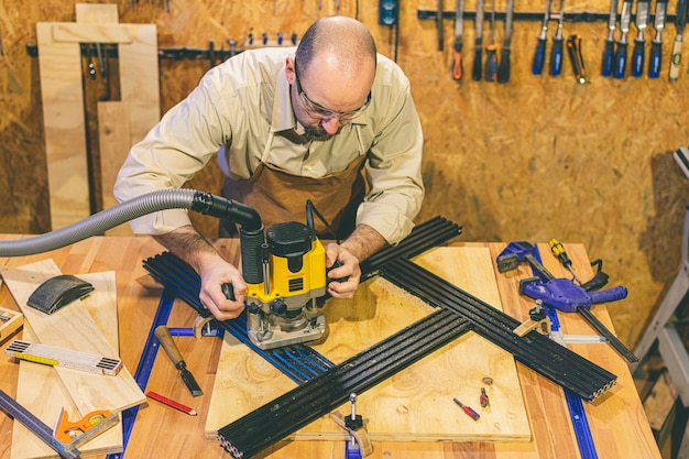 Artisan du bois à l'aide d'une fraiseuse verticale