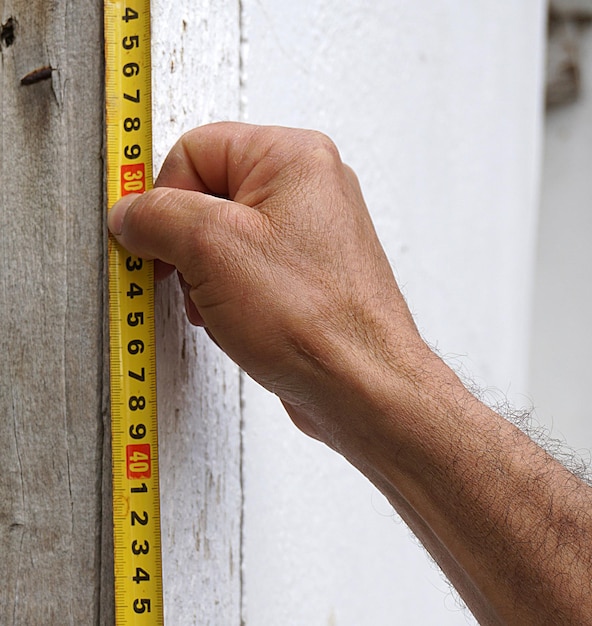 Photo un artisan engagé dans la mesure avec le calcul de la surface du ruban à mesurer avec le ruban à mesurer en acier