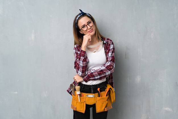 Artisan ou femme électricien avec des lunettes et souriant