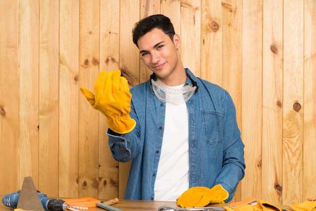 Artisan homme sur mur en bois invitant à venir