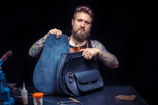 Artisan de sac à main en cuir au travail dans un atelier.