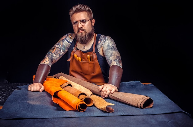 Artisan travaillant le cuir travaille le cuir./Leather homme crée une nouvelle maroquinerie dans son atelier.