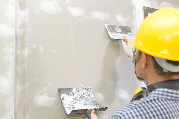 Artisan travaillant avec un plafond de gypse en plâtre pour un plafond en plaques de plâtre de construction intérieure