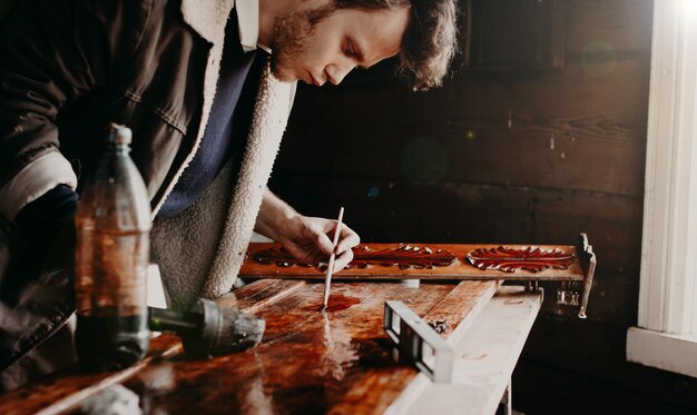 l'artisan travaille dans un atelier avec du bois vernis un élément de mobilier en bois