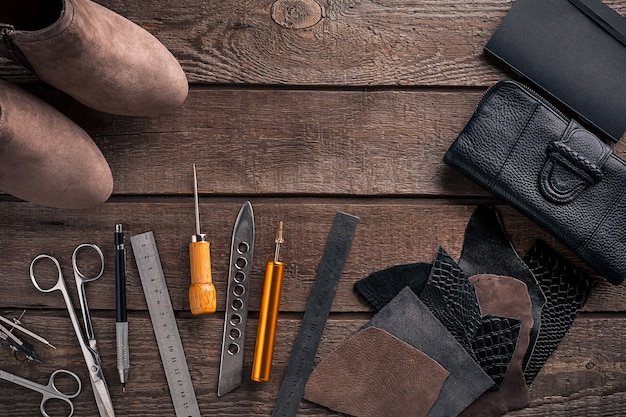 Artisanat du cuir ou travail du cuir, outils de travail du cuir et morceaux de cuir découpés sur le bureau