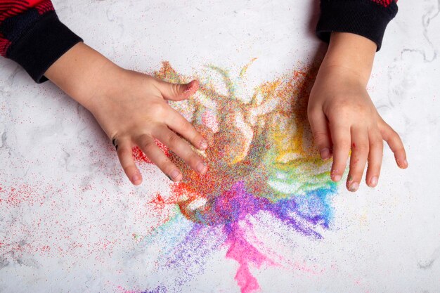 Artisanat à la main avec du sable coloré en gros plan Compétences motrices Concept de créativité de l'enfant