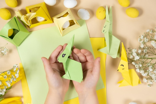 Artisanat à partir de papier pour l'origami de Pâques faisant des figurines de lapins de Pâques